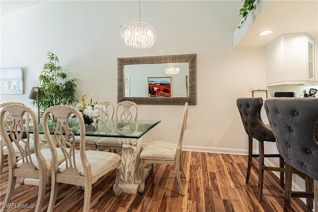 dining space with a chandelier, baseboards, and wood finished floors