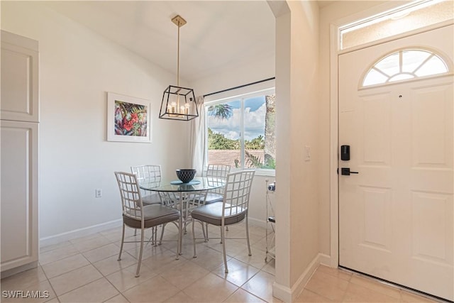 dining area with light tile patterned flooring, a chandelier, arched walkways, and baseboards