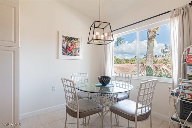 dining area featuring light tile patterned floors, baseboards, and a chandelier