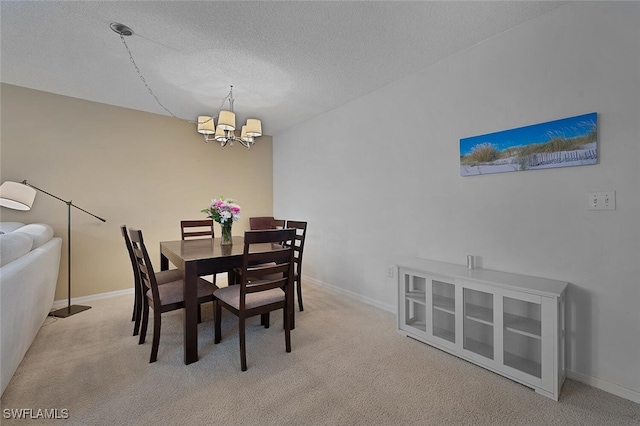 carpeted dining space featuring a textured ceiling and a chandelier