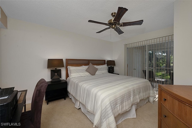 bedroom featuring ceiling fan, light colored carpet, and a textured ceiling