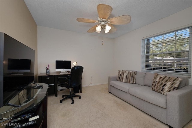 carpeted office space featuring ceiling fan and a textured ceiling