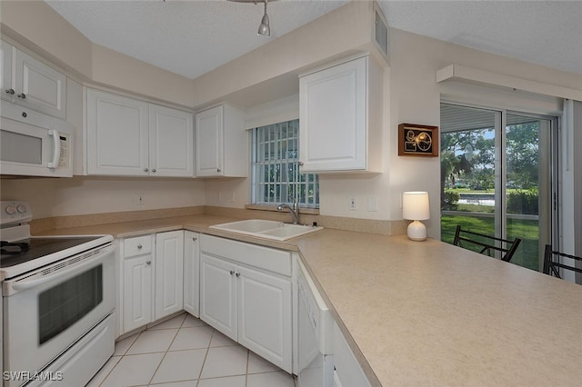 kitchen featuring white cabinetry, sink, a wealth of natural light, and white appliances