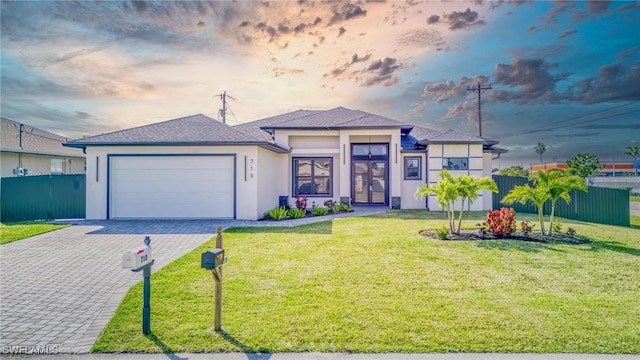 view of front of home with a yard and a garage