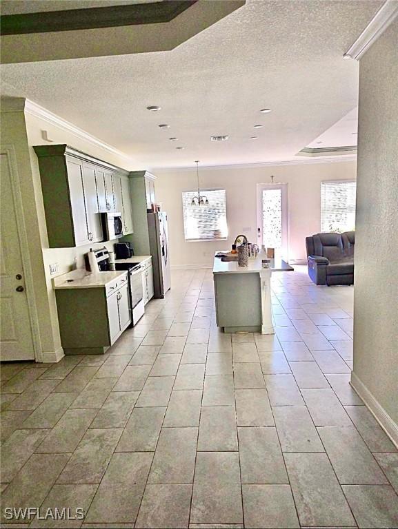 kitchen featuring light tile patterned flooring, appliances with stainless steel finishes, a textured ceiling, and decorative light fixtures