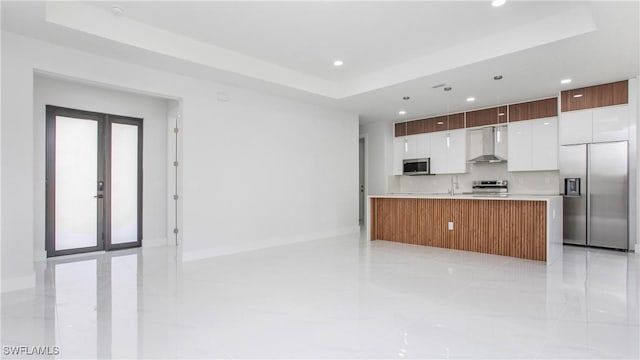 1420 Poinsettia Ave, Lehigh Acres, FL 33972 - kitchen with wall chimney range hood, white cabinets, appliances with stainless steel finishes, a raised ceiling, and modern cabinets