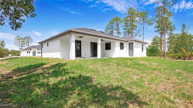 1420 Poinsettia Ave, Lehigh Acres, FL 33972 - back of house with a yard, a ceiling fan, and stucco siding