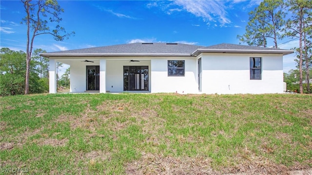 1420 Poinsettia Ave, Lehigh Acres, FL 33972 - back of property with ceiling fan, stucco siding, and a yard