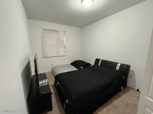 bedroom with light carpet and baseboards