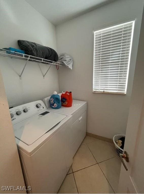 laundry room with light tile patterned floors, laundry area, baseboards, and independent washer and dryer