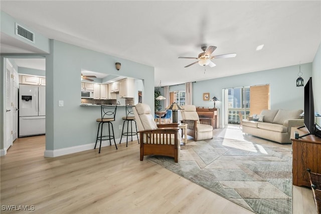 living room with light hardwood / wood-style floors and ceiling fan