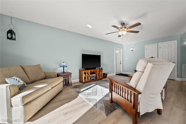 living room with ceiling fan and light hardwood / wood-style flooring