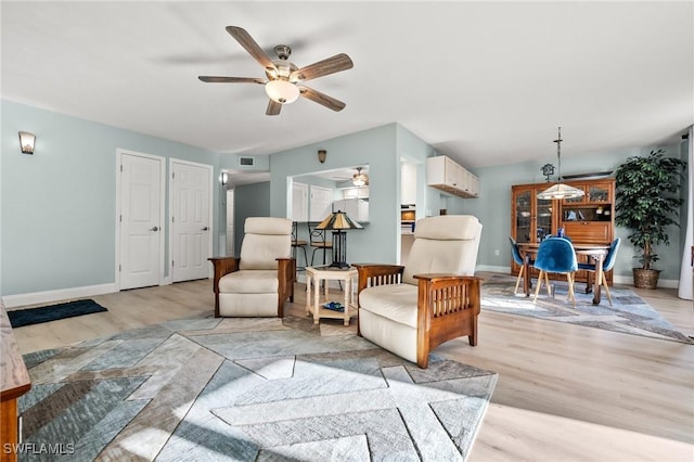 living area featuring ceiling fan and light hardwood / wood-style flooring