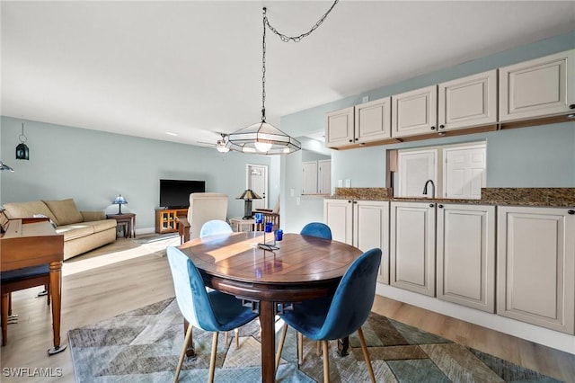 dining room with sink and light wood-type flooring