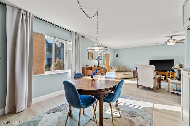 dining room featuring vaulted ceiling, ceiling fan, and light wood-type flooring