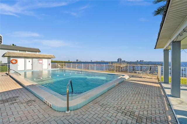 view of pool with a patio area and a water view