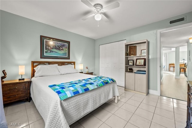 tiled bedroom featuring ceiling fan and a closet