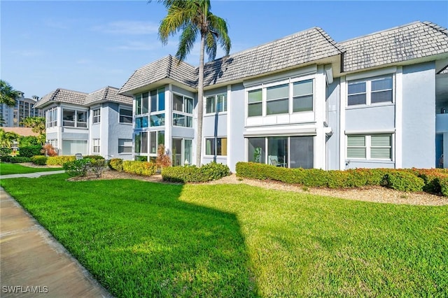 rear view of property featuring a lawn