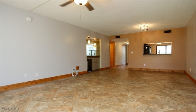 spare room featuring a healthy amount of sunlight, baseboards, visible vents, and a ceiling fan