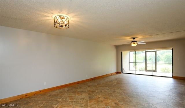 unfurnished room with a ceiling fan, a textured ceiling, and baseboards