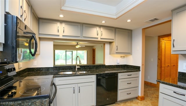 kitchen with a sink, visible vents, black appliances, dark stone countertops, and crown molding