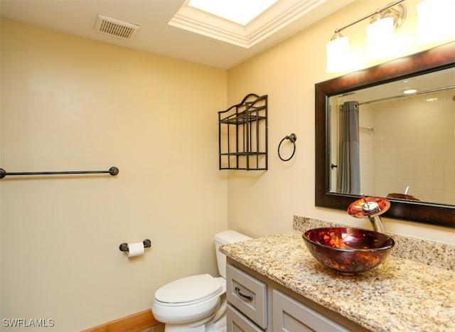 full bath with visible vents, toilet, vanity, baseboards, and walk in shower