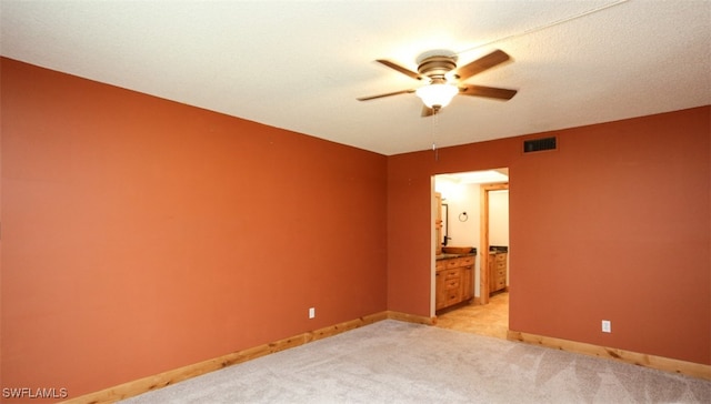 unfurnished bedroom with baseboards, connected bathroom, visible vents, and light colored carpet