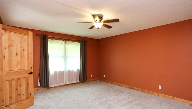 carpeted spare room with a ceiling fan, a textured ceiling, and baseboards