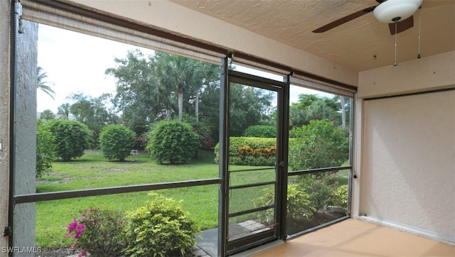 unfurnished sunroom featuring a ceiling fan