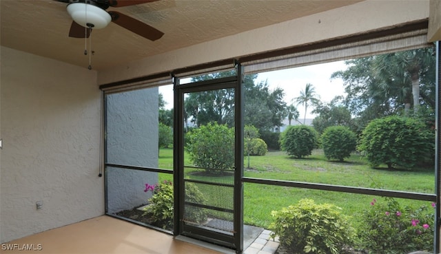 unfurnished sunroom with ceiling fan