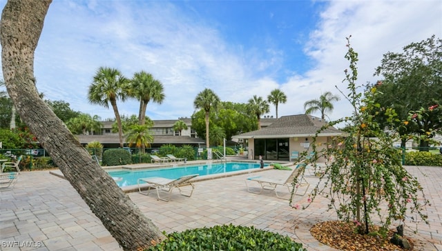 community pool with fence and a patio