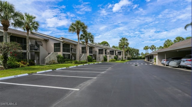 partially covered parking lot featuring a residential view