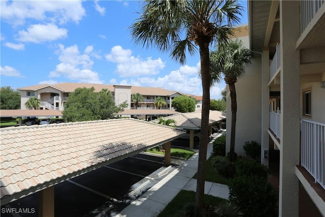 exterior space with a tile roof, a residential view, and parking