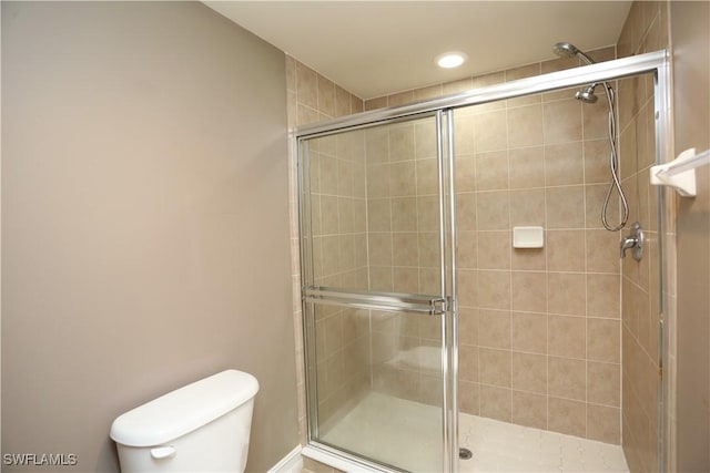 bathroom featuring toilet and a stall shower