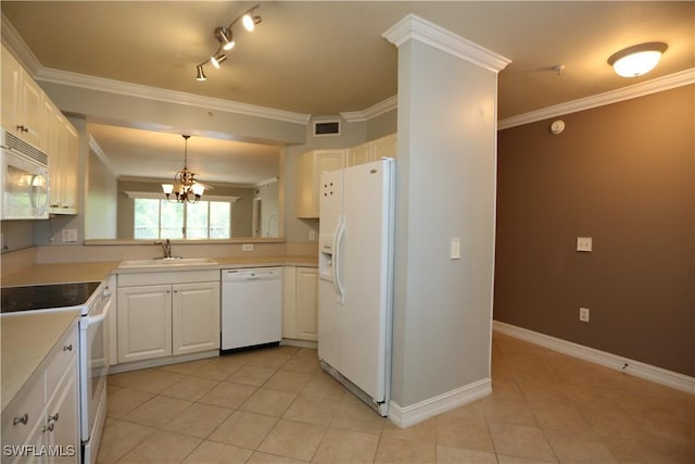 kitchen featuring white appliances, white cabinets, hanging light fixtures, light countertops, and a sink