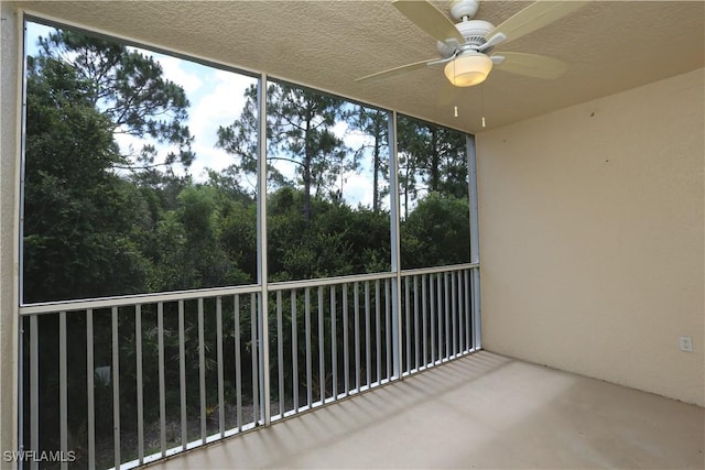 unfurnished sunroom featuring a ceiling fan