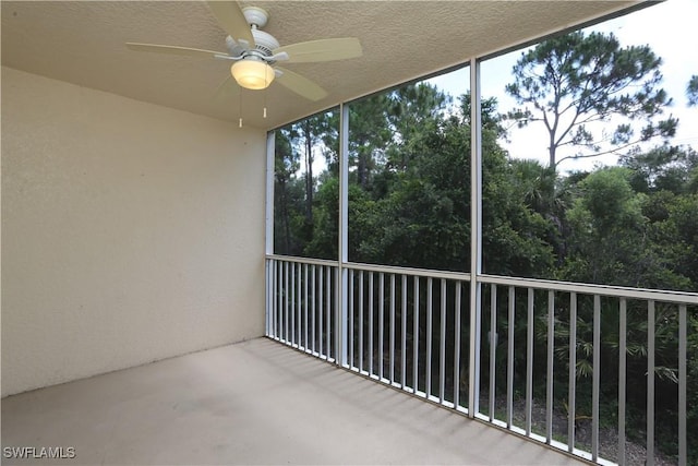 unfurnished sunroom featuring ceiling fan