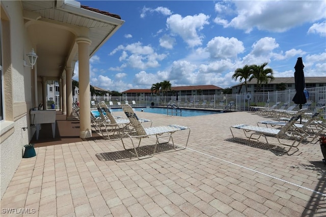 pool with a patio area and fence