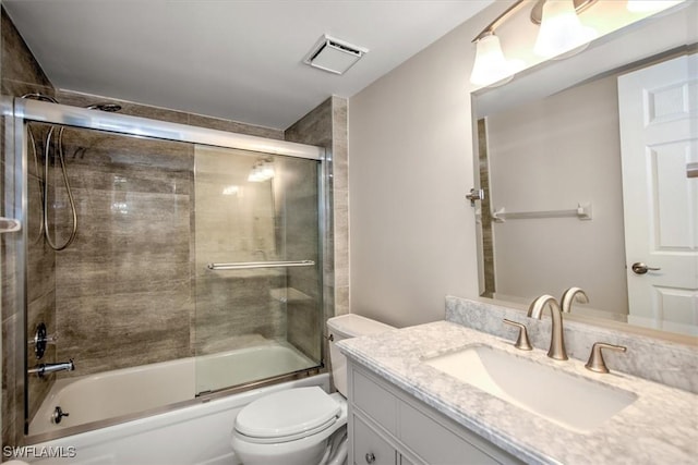 full bathroom with vanity, shower / bath combination with glass door, and toilet