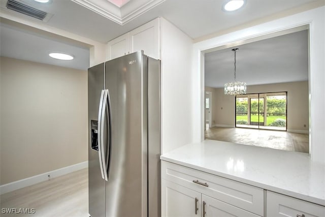 kitchen with stainless steel fridge with ice dispenser, pendant lighting, light stone countertops, light hardwood / wood-style floors, and white cabinets