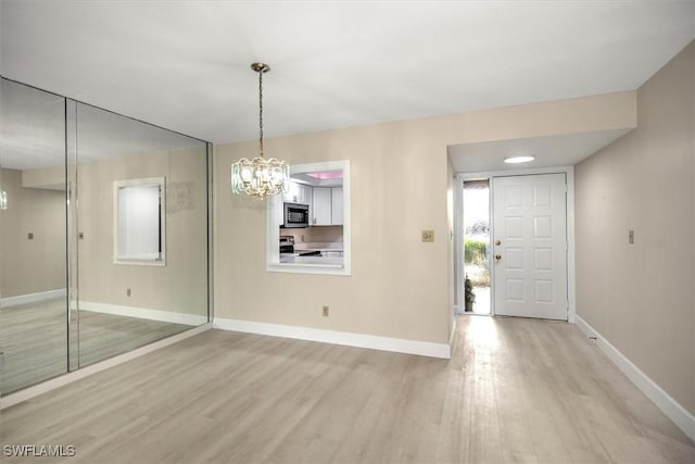 interior space featuring an inviting chandelier and light hardwood / wood-style floors