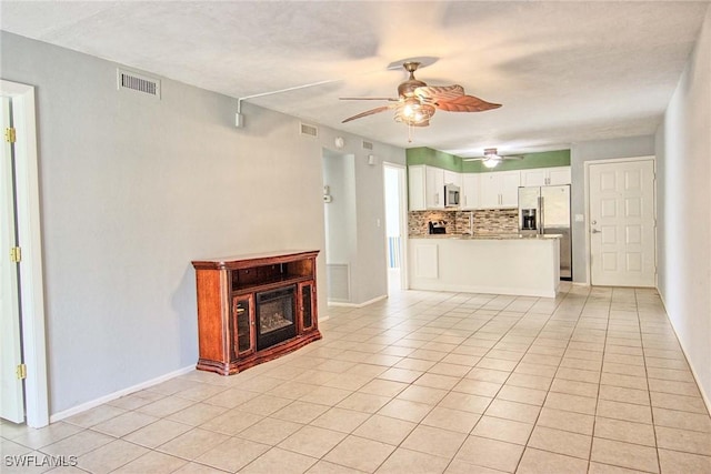 1100 Pondella Rd Unit 807, Cape Coral, FL 33909 - unfurnished living room featuring a ceiling fan, light tile patterned floors, a glass covered fireplace, and baseboards