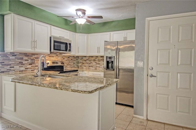 1100 Pondella Rd Unit 807, Cape Coral, FL 33909 - kitchen featuring stainless steel appliances, light tile patterned floors, a peninsula, and light stone counters