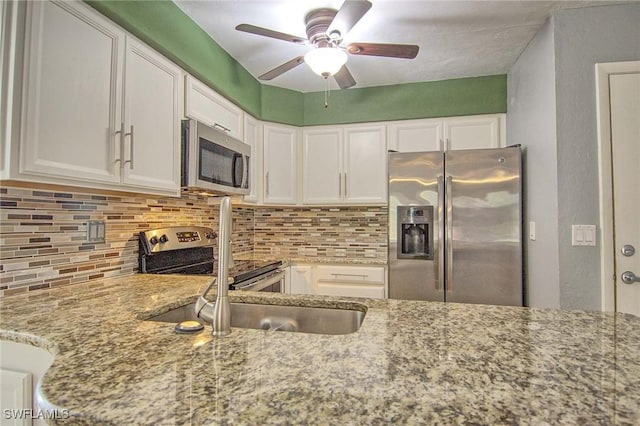 kitchen with white cabinetry, appliances with stainless steel finishes, and light stone counters