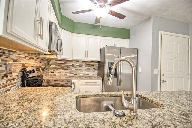 1100 Pondella Rd Unit 807, Cape Coral, FL 33909 - kitchen featuring appliances with stainless steel finishes, a sink, light stone countertops, white cabinetry, and a ceiling fan