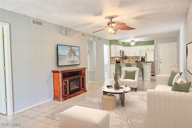 1100 Pondella Rd Unit 807, Cape Coral, FL 33909 - living area with light tile patterned flooring, ceiling fan, baseboards, and a glass covered fireplace