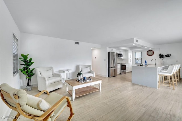 living room with sink and light hardwood / wood-style floors