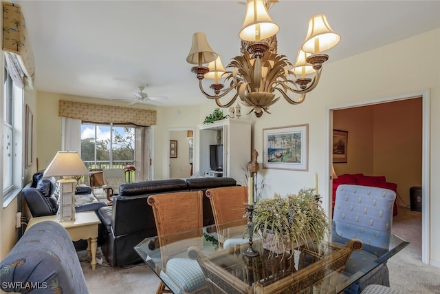 carpeted dining room featuring ceiling fan with notable chandelier