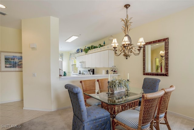 dining area with an inviting chandelier and light colored carpet