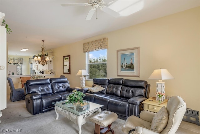 carpeted living room with ceiling fan with notable chandelier